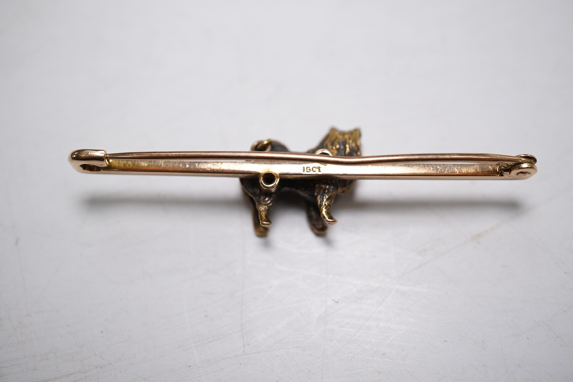 An Edwardian 15ct Corgi? bar brooch, 50mm, 7.2 grams. Condition - fair